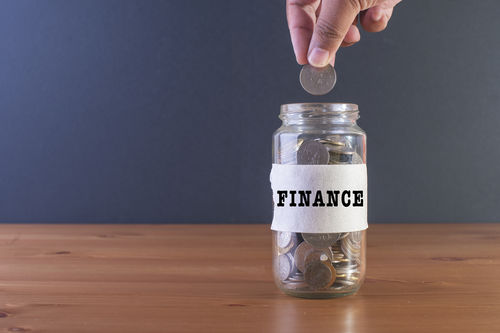 hand dropping quarter into finance jar.jpg